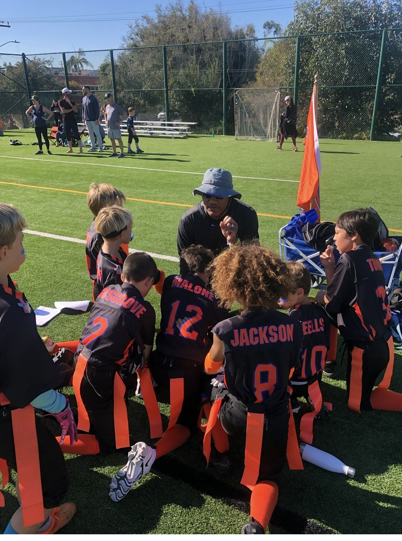 Kids in football uniforms on a field.