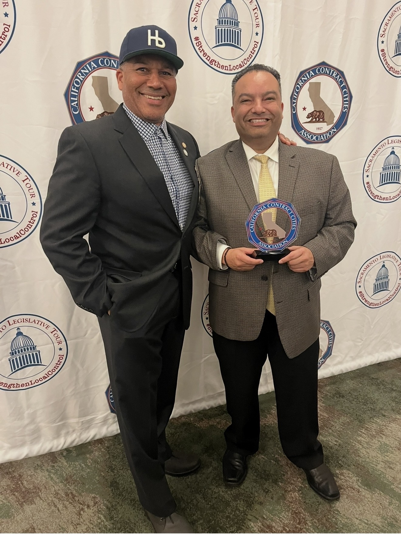 Ray Jackson posing with another man holding an award in front of a government seal.